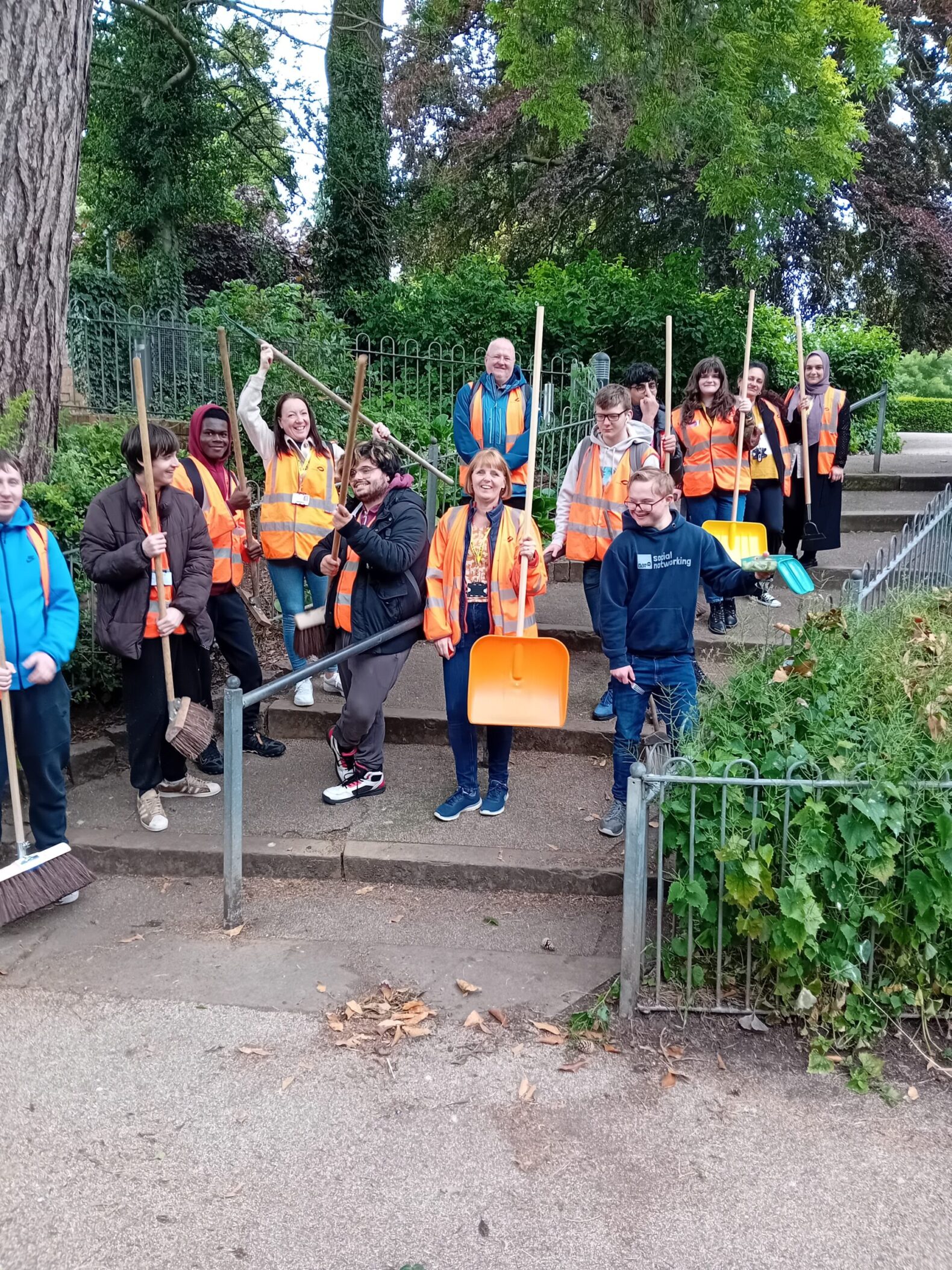 students in orange high vis vests standing on steps