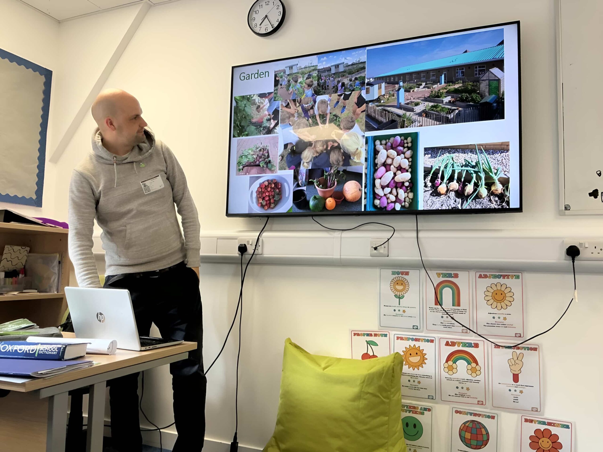 idverde presenter showing school garden project slides on a classroom display screen with HP laptop