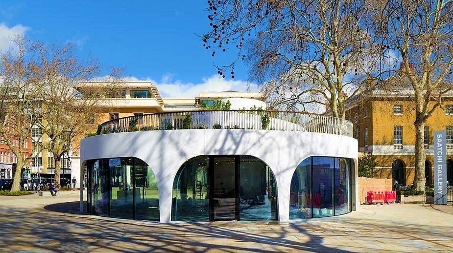 Modern circular glass pavilion at Saatchi Gallery, Chelsea, surrounded by mature plane trees and landscaped grounds