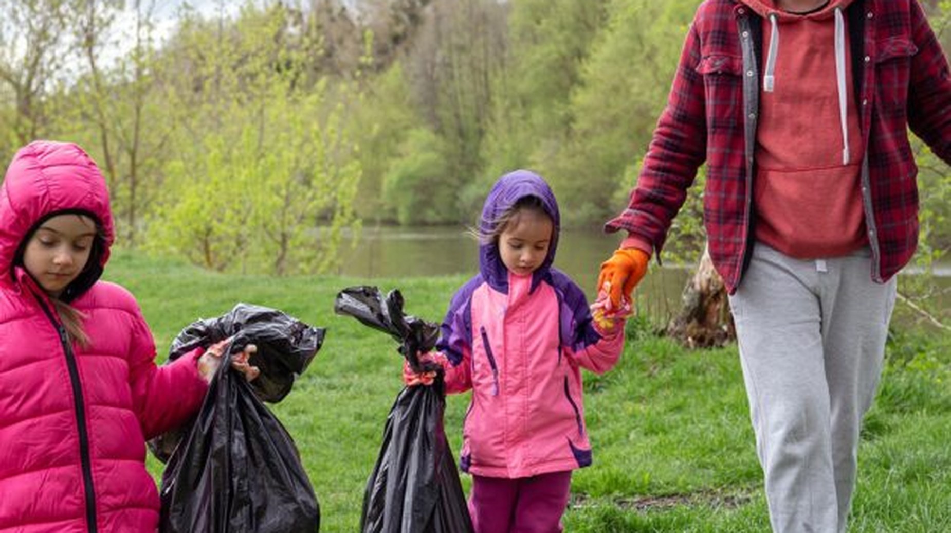 Children and adult holding bin bags during a community litter-picking clean-up