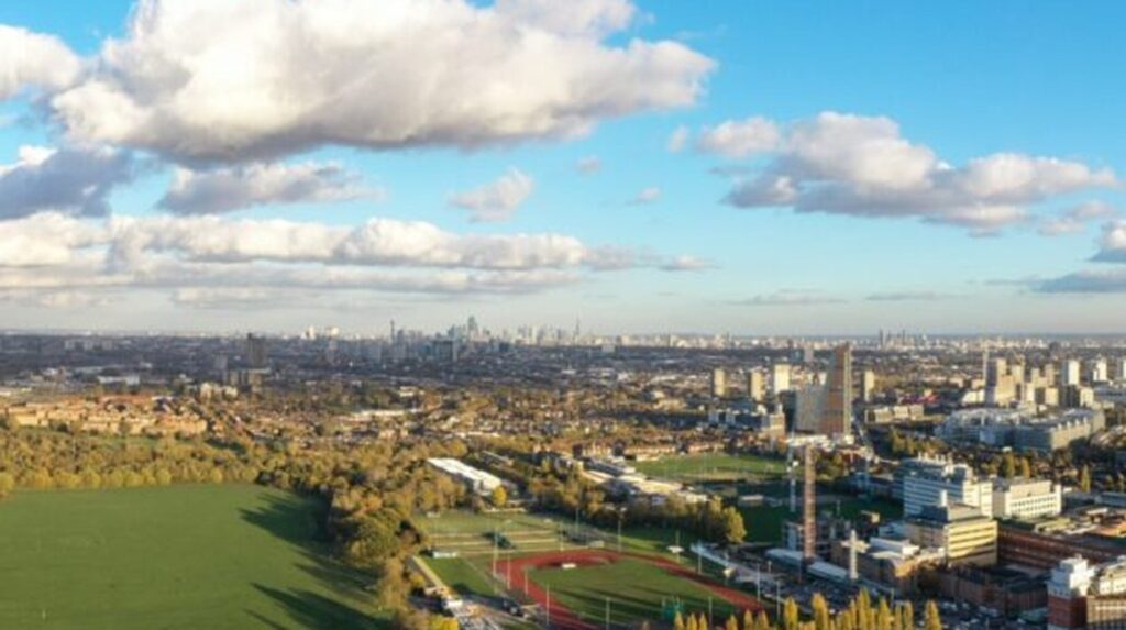 Aerial view of urban green spaces and sports fields amid city skyline