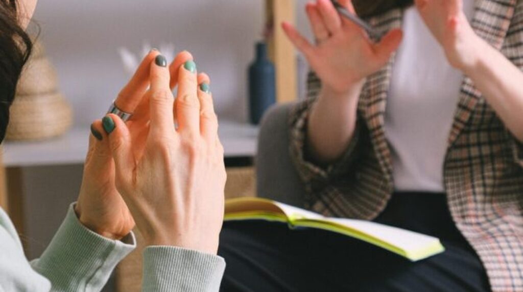 Two people in discussion, one gesturing while the other listens attentively